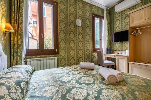 a bedroom with a bed with towels on it at Cà Beatrice in Venice