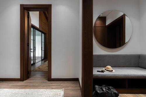 a hallway with a mirror and a bench with a hat at Burchmulla Resorts in Burchmulla