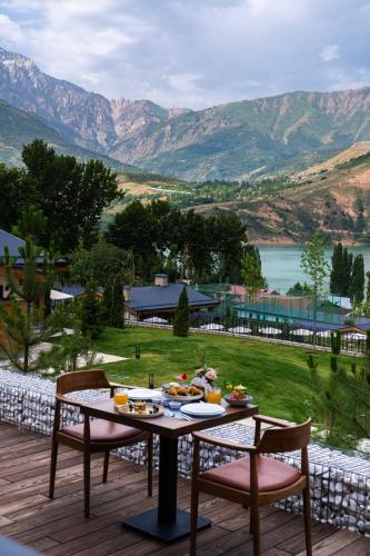a table with food on it on a deck with mountains at Burchmulla Resorts in Burchmulla