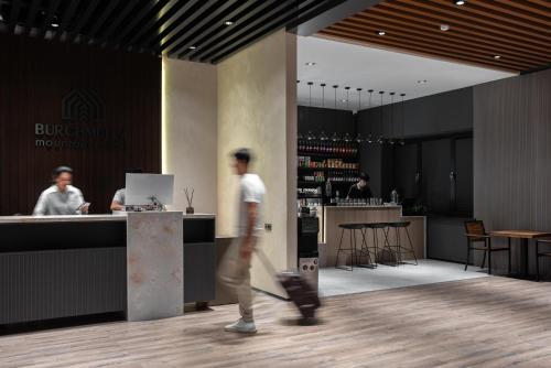 a man walking past a bar in a restaurant at Burchmulla Resorts in Burchmulla