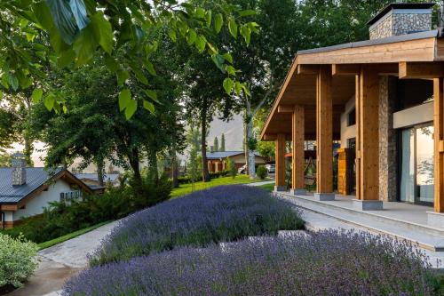 a garden with purple flowers in front of a building at Burchmulla Resorts in Burchmulla