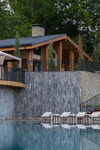 a house with a swimming pool next to a wall at Burchmulla Resorts in Burchmulla