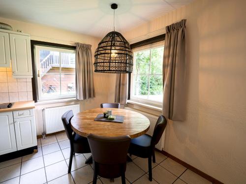a dining room table with chairs and aendant light at 't Eekhoornnest in Soest