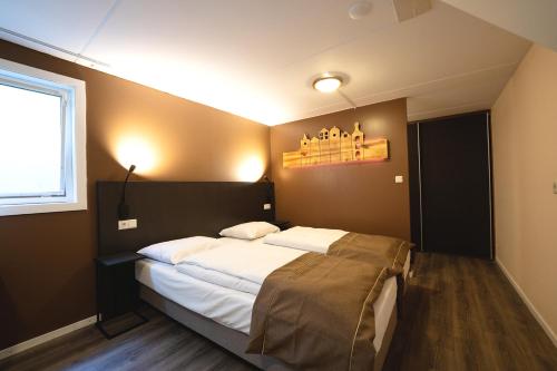 a bedroom with a large bed and a window at 't Eekhoornnest in Soest