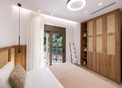 a bedroom with a white bed and wooden cabinets at Innamorata Sivota in Sivota