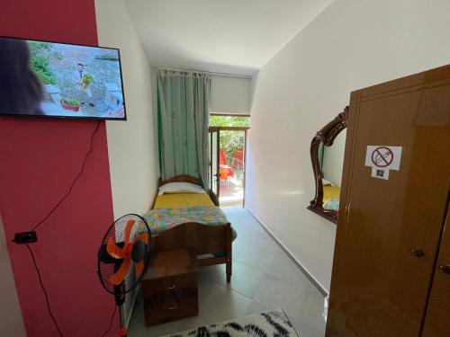 a small room with a bed and a tv on the wall at Hotel Bar Restaurant Mete in Peshkëpi