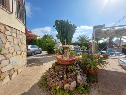 a garden with a fountain in the middle of a driveway at Chalet Los Almendros con piscina privada in Calpe
