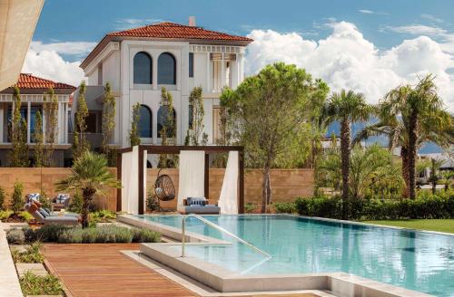 a villa with a swimming pool in front of a house at One&Only Portonovi in Herceg-Novi