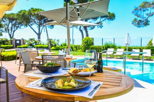 a table with a plate of food and glasses of wine at Hotel Corte Valier in Lazise
