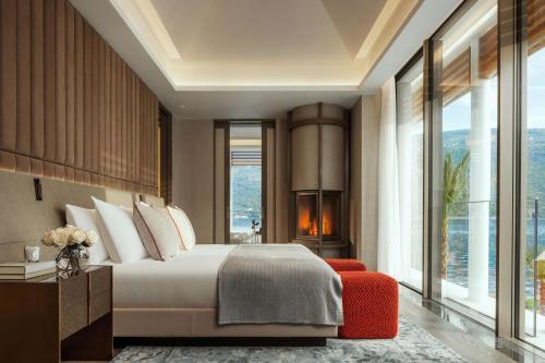 a bedroom with a bed and a large window at One&Only Portonovi in Herceg-Novi