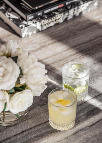 two glasses with a drink and flowers on a table at One&Only Portonovi in Herceg-Novi