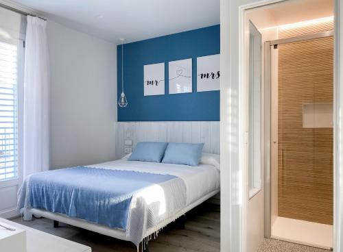 a bedroom with a bed with blue walls and a door at Nerja Casual Rooms in Nerja