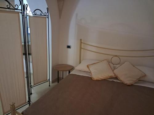 ein Schlafzimmer mit einem Bett mit zwei Kissen darauf in der Unterkunft Casa Angolo dei Sogni in Martina Franca