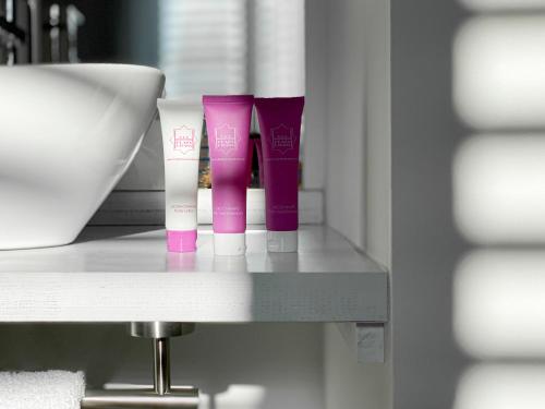 a shelf with three tubes of pink and white products at Nerja Casual Rooms in Nerja