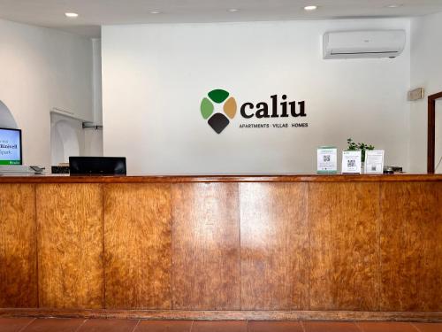 un mostrador de madera con un cartel en la pared en Binivell Park - Caliu Apartments, en Binibeca