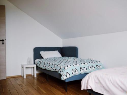 a bedroom with a blue couch and a bed at Wine Residence Kerman - Wine and Wellness Retreat in Sveti Urban in Štrigova
