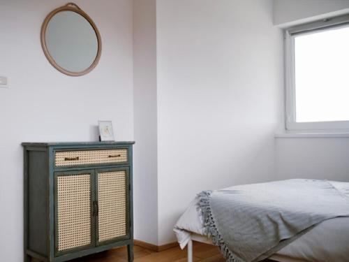 a bedroom with a bed and a mirror on the wall at Wine Residence Kerman - Wine and Wellness Retreat in Sveti Urban in Štrigova