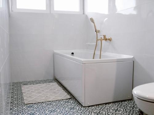 a white bathroom with a tub and a toilet at Wine Residence Kerman - Wine and Wellness Retreat in Sveti Urban in Štrigova