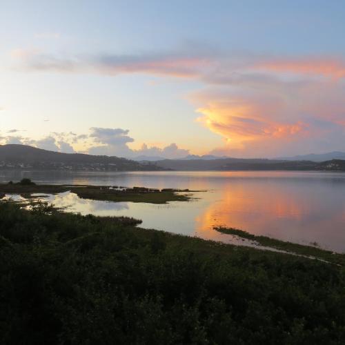 a sunset over a body of water with islands at "The Gatehouse", Goosebumps - Cottage in Lake Brenton on Knysna Lagoon in Brenton-on-Sea