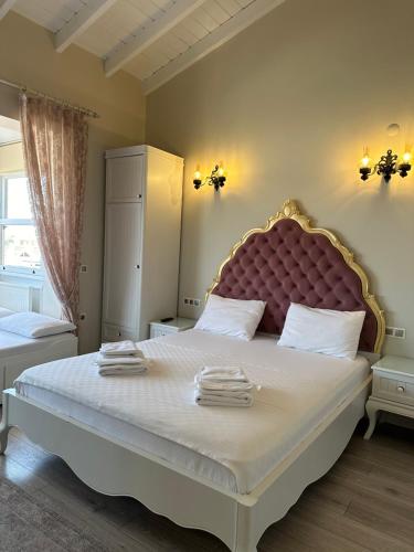 a bedroom with a large bed with a large headboard at Grand Alaçatı Butik Hotel in Alacati