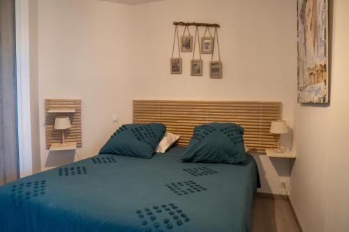 une chambre avec un lit avec des draps et des oreillers bleus dans l'établissement T2! 3 ou 4 personnes centre ville neuf avec garage, à Sanary-sur-Mer