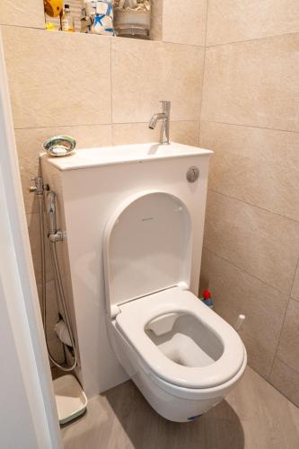 La salle de bains est pourvue de toilettes blanches avec un couvercle. dans l'établissement T2! 3 ou 4 personnes centre ville neuf avec garage, à Sanary-sur-Mer