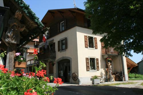 un grand bâtiment avec des fleurs devant lui dans l'établissement Appartement Zian Justine, à Lullin
