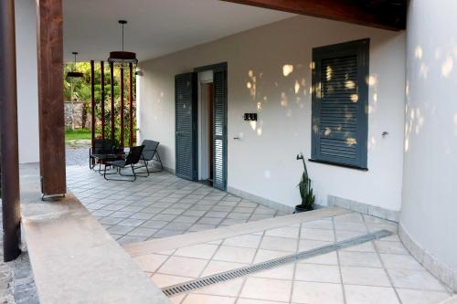 a porch with black doors and a table and chairs at Dream Garden in Scafati