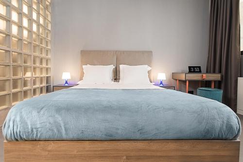 a bedroom with a large bed with two lamps at Avangarda Suites in Belgrade
