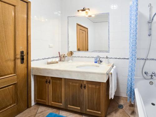 un bagno con un lavandino, uno specchio e una vasca di Prainha Loft Apartment ad Alvor