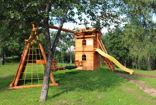 a playground with a play house and a slide at Weavers' Guest House Kalndaki in Milzkalne