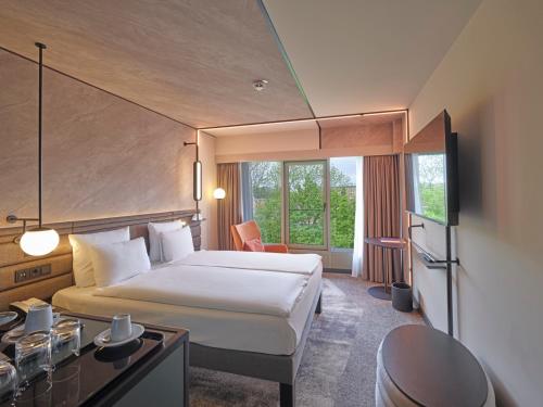 a hotel room with a bed and a window at Novotel München City in Munich