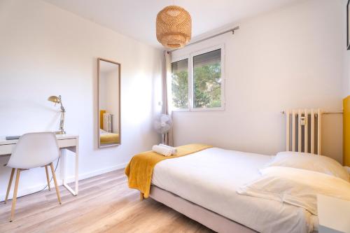 une chambre avec un lit, un bureau et une fenêtre dans l'établissement Appartement cosy et raffiné proche gare Toulon, à Toulon