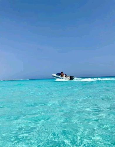 a man is in a boat in the ocean at شاليه ديمورا عائلات فقط Dimora Chalet Only Family in Dawwār Muḩammad Abū Shunaynah