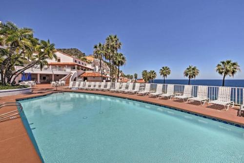 a swimming pool with chairs and the ocean in the background at Gorgeous Oceanfront Villa With Panoramic Views in Avalon