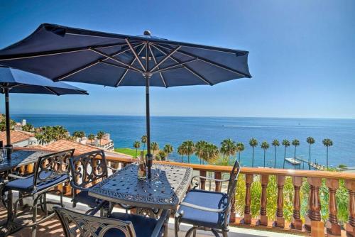 a patio with tables and chairs and an umbrella at Oceanfront Villa With Breathtaking Views in Avalon