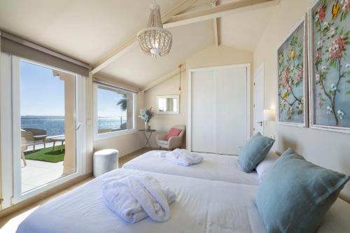 two beds in a room with a large window at Punta Carnero Alojamiento Singular in Algeciras