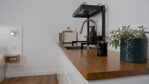 a kitchen counter with a sink and a microwave at V&J Guest Suite in Machico