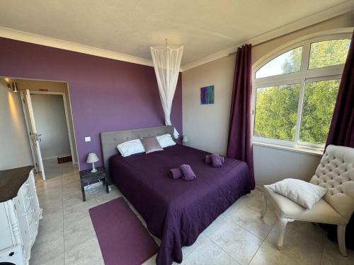 a bedroom with a purple bed and a chair at Beach House Lagos - Beachhouselagos - Meia Praia in Lagos