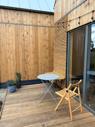 a table and a chair on a wooden deck at Morska 2K in Łukęcin