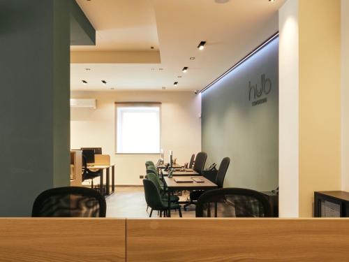 a dining room with tables and chairs and a wall with a nord sign at HUB Rooms in Carini