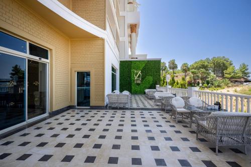 a patio with chairs and tables on a building at Oz Hotels Sui in Alanya