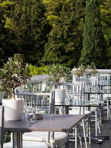 a row of tables and chairs with potted plants on them at St George Lycabettus Lifestyle Hotel in Athens