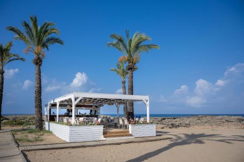 a gazebo on the beach with palm trees at Oz Hotels Incekum Beach in Alanya