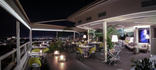 a restaurant with tables and chairs on a balcony at night at St George Lycabettus Lifestyle Hotel in Athens