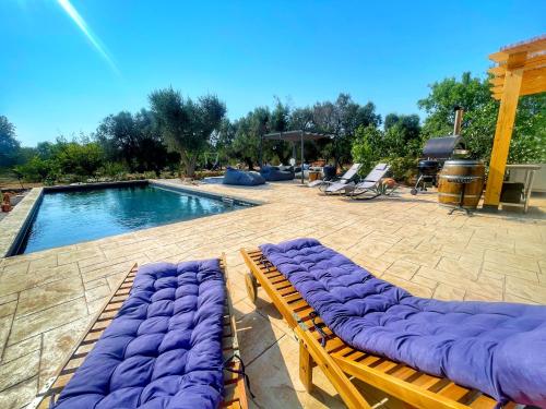 two chaise lounges sitting next to a swimming pool at Trullideserio in San Michele Salentino
