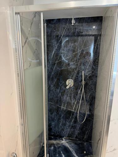 d'une douche avec une porte en verre. dans l'établissement Residence du Casino, à Menton