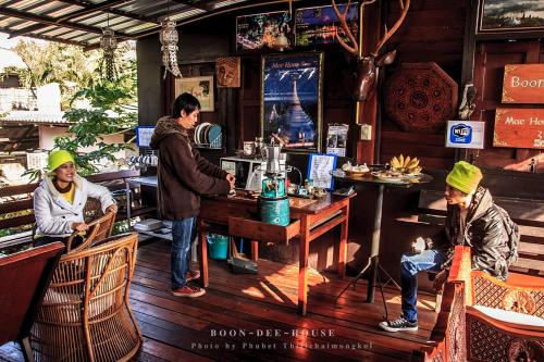 a group of people sitting at a table in a restaurant at Boondee House in Mae Hong Son