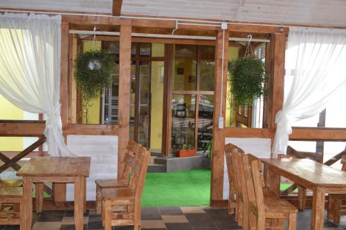 a dining room with a table and chairs and windows at Hotel Restaurant Vizit in Truskavets