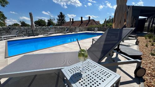 a drink on a table next to a swimming pool at Bohém Borklub in Tállya